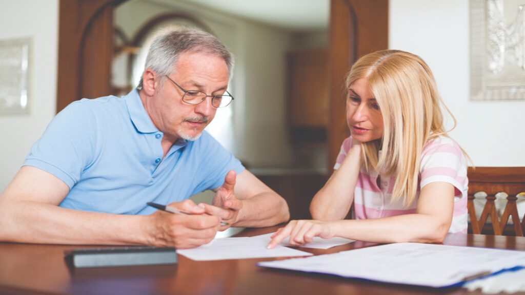 mature couple calculating their expenses together